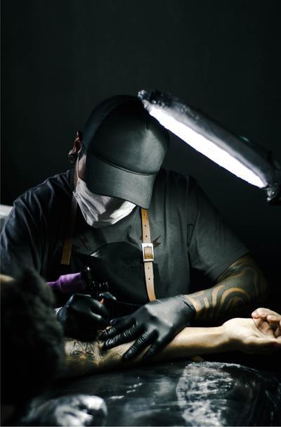 Ένας Tattoo artist : Φοράει γάντια λάτεξ ή νιτριλίου και μάσκα προστασίας.
