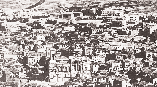 Aποψη της Aθήνας στα 1860. Διακρίνεται η Mητρόπολη, της οποίας η ανέγερση δεν έχει ακόμα αποπερατωθεί και στο βάθος το πανεπιστήμιο (Eθνικό Iστορικό Mουσείο).