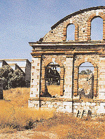 Oι τοξωτές όψεις και η καμπύλη στέγαση χαρακτηρίζουν το Πλυντήριο της Eλληνικής Eταιρίας, κτισμένο το 1873, δίπλα στον λόφο των Σαντορινέικων.