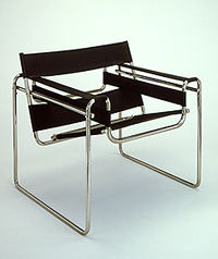 σχεδιασμένων πάνω σε απλές γεωμετρικές μορφές με σύγχρονα υλικά (βλ. εικ. 17) όπως: καθίσματα από μεταλλικούς σωλήνες, προκατασκευασμένα έπιπλα, λάμπες γραφείου κ.ά. (E.