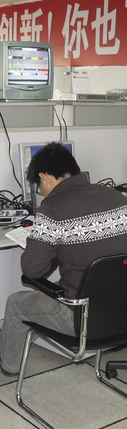 Inside the Hardware Test Center Ο Wang Xiao Bo είναι διαχειριστής του Κέντρου Δοκιμών Υλικού της Changhong και ποζάρει μπροστά από μια επαγγελματική συσκευή μέτρησης R&S.