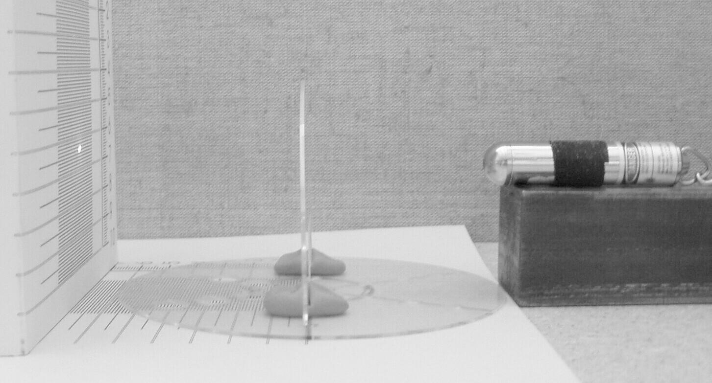 Obr. 1a Znázornenie experimentu: S-stojan, D-držiak, CD-disk CD, na ktorý sa pozeráme z boku, L- laserové ukazovátko,prerušovaná čiara označuje lúč vychádzajúci z ukazovátka, rozštiepený na tri lúče