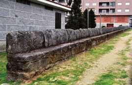 formada por unha cruz con dúas patas inferiores. A abundancia do M indica que se trataba dun obradoiro e non dun canteiro, que labrou máis pedras que todos os demais.