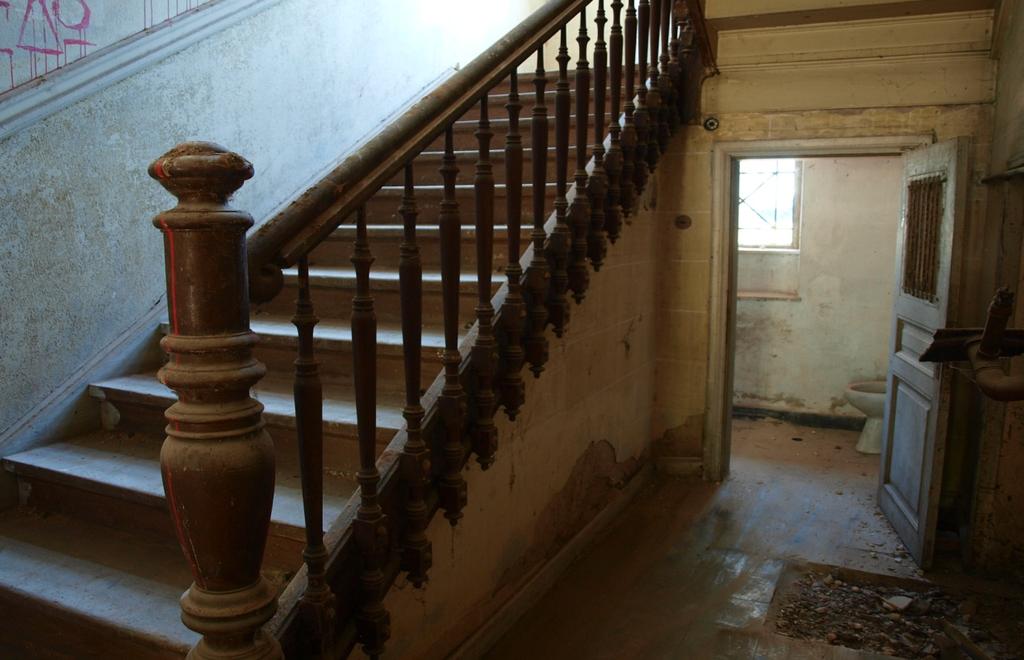 Η σκάλα που οδηγεί στον όροφο είναι και αυτή ξύλινη με περίτεχνα κιγκλιδώματα και έχει 28 πατήματα.