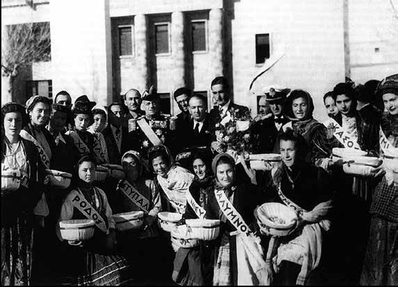 7 Μαρτίου 1948. Ὁ Ἀντιναύαρχος Ἰωαννίδης, ὁ Δήμαρχος Γαβριήλ Χαρίτος καί οἱ νεαρές κοπέλες πού ἔφεραν τήν σημαία σέ ἀναμνηστική φωτογραφία.