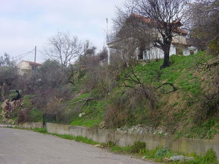 Το σπίτι με αρκετά επικλινή στέγη στο Λιβαδάκι και το νέο στην κάτω μεριά του δρόμου