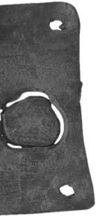 Правоугаона плочица од олова, димензија 8,0 x 4,2 cm, са кружним перфорацијама за причвршћивање на подлогу. Курзивни натпис урезан у једном реду.