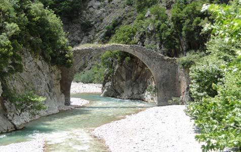 τον αρχαιολογικό χώρο στη θέση «Ελληνικά», δίπλα στο εκκλησάκι του Αγίου Μηνά και γεφυρώνει έναν παραπόταμο του Αχελώου.