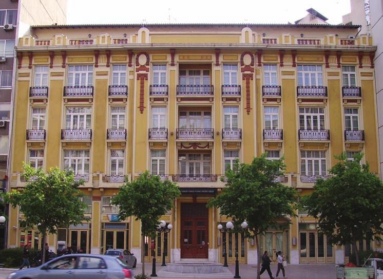 building, designed by architect Vitalliano Poselli, with its two facades with unimpeded views of Chrimatistiriou Square and Vilara Street, was organized around a central space in the full height of