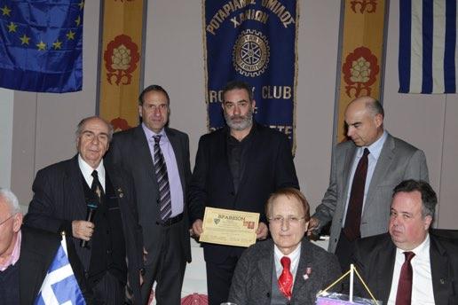 Το επιδίδουν ο Πρόεδρος του Εμποροβιομηχανικού Επιμελητηρίου κ.στρογγυλός και ο Καθηγητής Ιατρικής και Ακαδημαικός Σεραφείμ Καστανάκης.