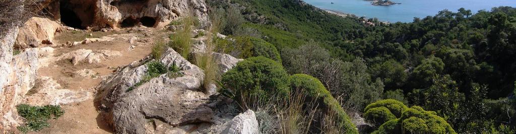 Θέα από το άνδηρο του σπηλαίου προς τον Σαρωνικό, με τις βραχονησίδες του Όρμου Περιστέρια, στον ορίζοντα.
