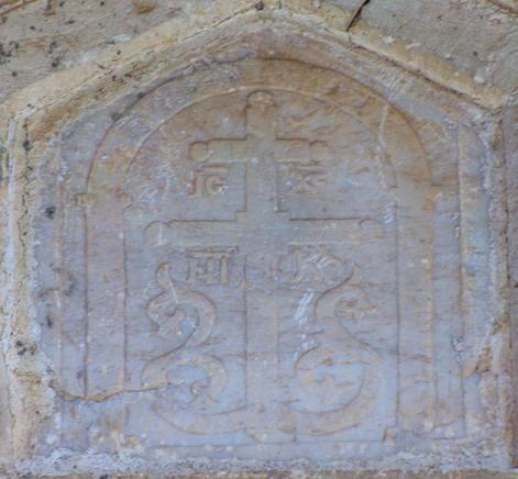 Μαρμάρινη πλάκα Βρίσκεται εντοιχισμένη στο τύμπανο του τόξου των παραστάδων της νότιας όψης. Αποδίδεται με την επιπεδόγλυφη τεχνική.