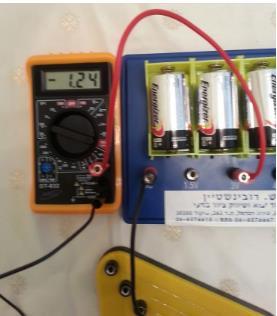 שאלה 5 תלמיד חיבר את המעגל המתואר, וקיבל קריאת זרם שלילית, כמוראה בצילום. הסבירו: מה משמעות הסימן השלילי במד הזרם?