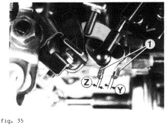 - Postaviti vijak M8 (strelica) slika 32 između poluge i tijela karburatora. - Zatvoriti priključak (1) i, ako postoji (2), slika 33.