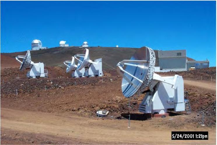 7. irudia: SMAko 4 antena. Atzean, Mauna Kean dauden beste teleskopio batzuk ikusten dira. Smithsonian Astrophysical Observatory erakundeak eskainitako irudia.