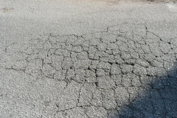 Πρόκειται για σύνολο διακλαδιζόμενων ρηγματώσεων μέσου πλάτους 5 mm, αλιγατορικής μορφής, στο ίχνος των τροχών, οι