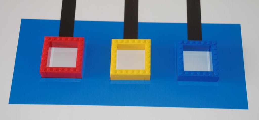 Τα αντικείμενα της δοκιμασίας Τα «σταφύλια» είναι 9 πλαίσια 5,5Χ5,5 εκατοστά, 3 κόκκινα, 3 κίτρινα, και 3 μπλε, που τοποθετούνται με κλήρωση στις 9 θέσεις των χώρων παραγωγής.