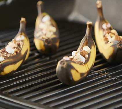 2 Κόψτε τις δύο σοκολάτες κατά μήκος στη μέση και τοποθετήστε ένα κομμάτι μέσα σε κάθε μπανάνα. 3 Βάλτε πάνω από τις μπανάνες τα μίνι μαρσμέλοους.
