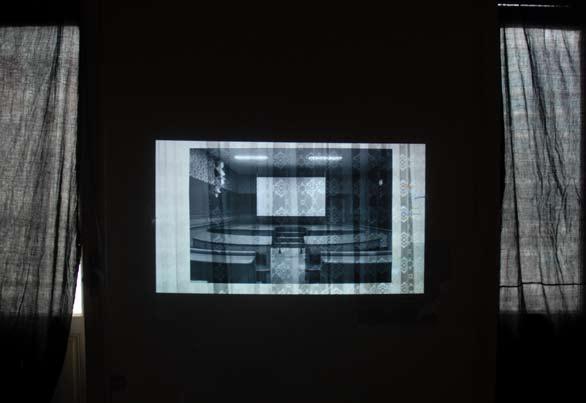 A film projected on a photograph depicting a former courtroom, now an exhibition space,