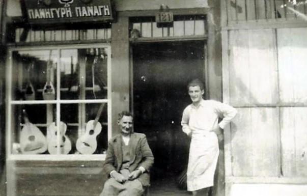 Εικόνα 10: Το οργανοποιείο του Πανηγύρη Παναγή. Καθιστός έξω από το μαγαζί του, με έναν από τους γιους του.
