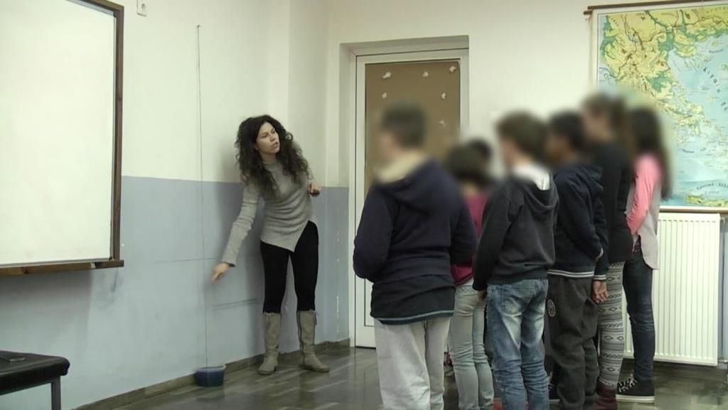 Εικόνα 33: Οι μαθητές παρατηρούν τη φυσική καθετότητα μεταξύ του νήματος της στάθμης και της επιφάνειας χρωματισμένου υγρού που ηρεμεί Στη συνέχεια, και πάλι με τη διαδικασία της επίδειξης ώστε να