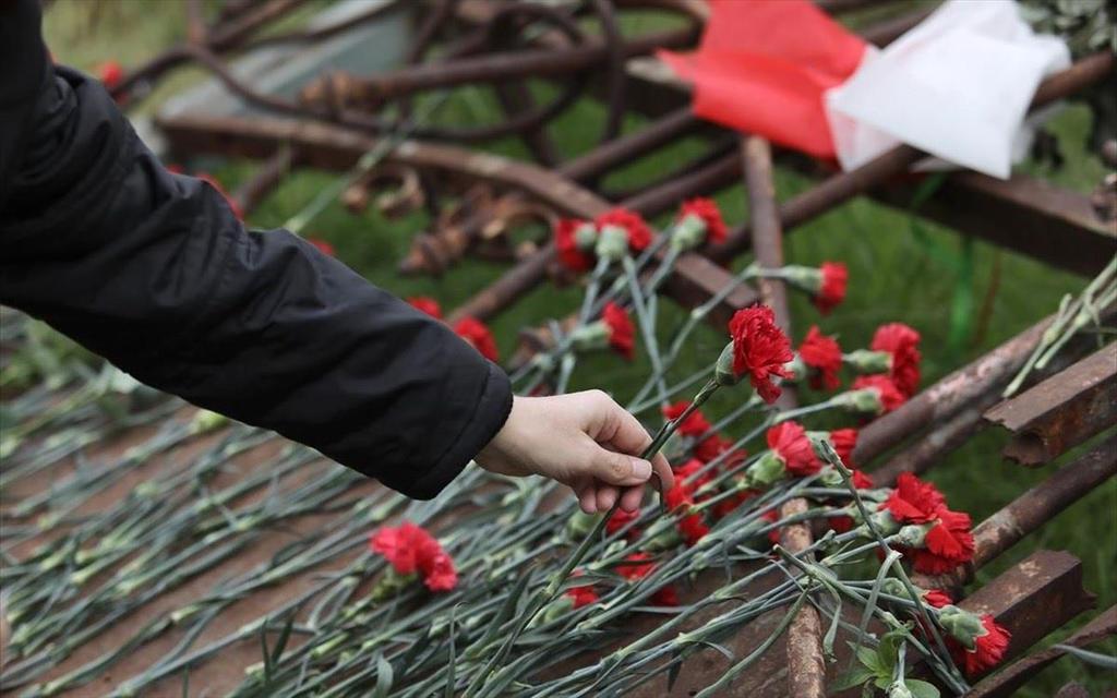 Κατάθεση κόκκινων γαρύφαλλων στη πύλη του Πολυτεχνείου που γκρέμισε το άρμα μάχης Πηγή εικόνας: