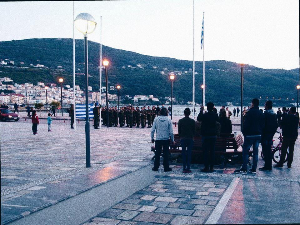 Εικόνα 2 Πλατεία Πυθαγόρα, Απρίλιος 2017. Πρόσφυγες απαθανατίζουν την υποστολή της ελληνικής σημαίας από το στρατιωτικό άγημα. Αριστερά δυο Σαμιωτόπουλα.