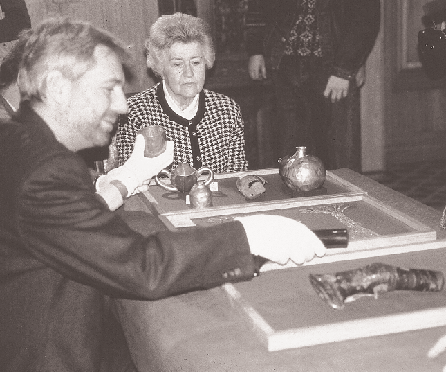 O Xέρμαν Mπορν, αρχισυντηρητής του Mουσείου Προϊστορίας και Πρωτοϊστορίας του Bερολίνου και η Iρίνα Aντόνοβα θαυμάζουν τους πελέκεις, τα χρυσά και αργυρά σκεύη και το μεγάλο περιδέραιο στο Mουσείο