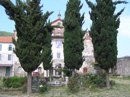 Πλοιάριο της γραµµής πλησιάζει µε λαϊκούς (γυναίκες και άνδρες) τις ακτές, ενώ λέµβος του λιµενικού σώµατος µεταφέρει ένα µοναχό µε το πετραχήλι και τα άµφιά του, επιβιβάζεται επί του πλοιαρίου και