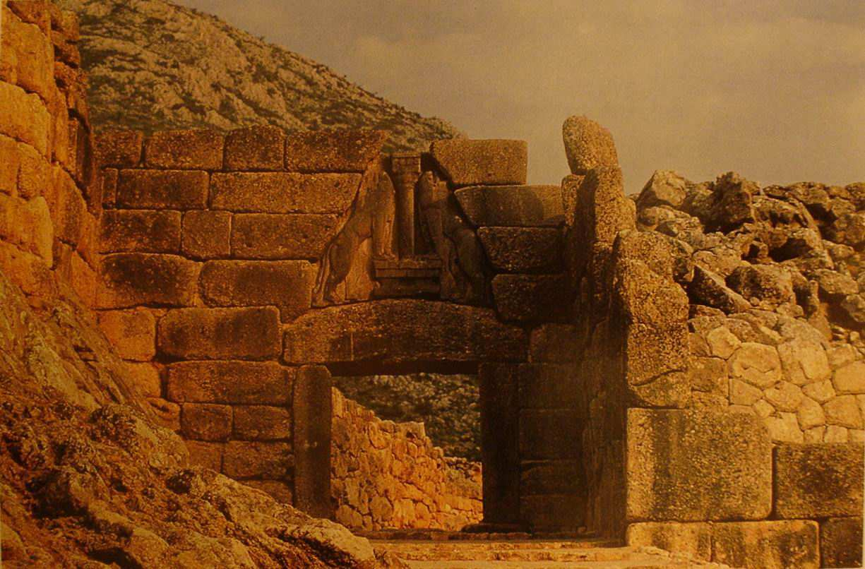 Τίτλος: Πύλη των λεόντων Χρονολογία: 1300 π.χ. Υλικό: Πέτρα Περιγραφή: Η έξοδος της πόλης προστατεύεται από την µία µεριά µε ένα τοίχο και από την άλλη µε προεξέχοντα προµαχώνα.