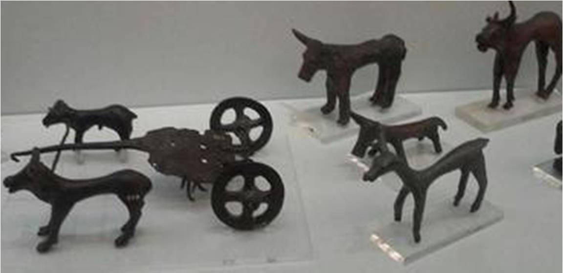 εικόνα 4: Χάλκινο ομοίωμα δίτροχου άρματος που το σέρνουν κριάρι και ταύρος, καθώς και χάλκινα ειδώλια ταύρων και ελαφιού (Μουσείο Ηρακλείου).
