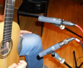 Τοποθετεί στε δυο μικρόφωνα στα αριστερά της οπής σε απόσταση 20 cm από τη κιθάρα και
