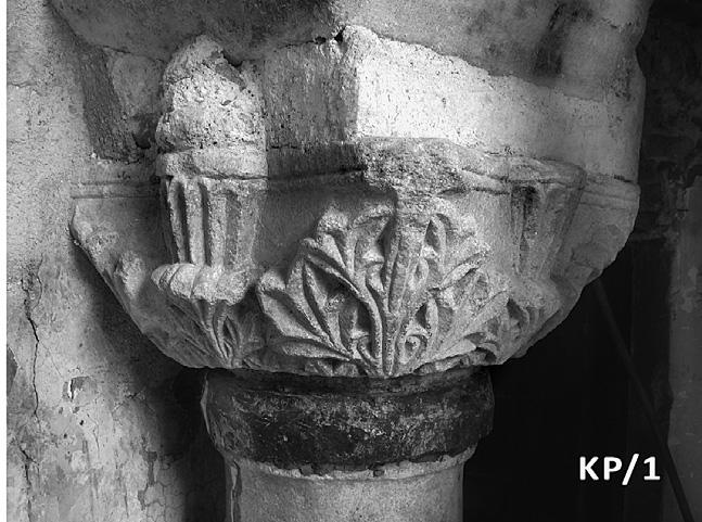 Από ένα μικρότερο φύλλο αναπτύσσεται στο μέσον κάθε όψης του κιονοκράνου και ανακρα- τά ευμέγεθες κομβίο με ριπιδιόσχημο κόσμημα, το οποίο εξέρχεται των ορίων του άβακα και εισχωρεί στον κάλαθο.