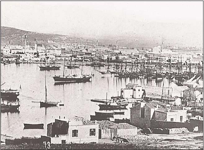 Εικόνα 1.10 : Aποψη τυ Πειραιά, γύρω στα 1880. Στο βάθος τα εργοστάσια με τις καμινάδες τους, η βαριά βιομηχανία της χώρας είχε κάνει τα πρώτα της βήματα.