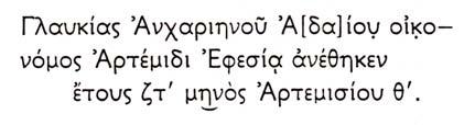 μακρύ απόπτυγμα. Το ένδυμα έχει αποδοθεί με βαθιές κατακόρυφες πτυχές μεταξύ των μηρών. Το κεφάλι και τμήμα του κορμού έχει υποστεί φθορά επομένως οι λεπτομέρειες διακρίνονται με δυσκολία.