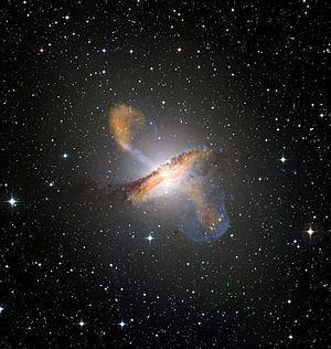 Σύνθετη εικόνα του Κένταυρου Α που συνδυάζει οπτικό φως, ακτίνες Χ (μπλε) και ραδιοκύματα (πορτοκαλί). Διακρίνονται οι λοβοί και οι πίδακες του γαλαξία.