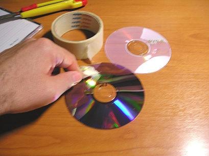 χρησιμοποιήσουμε) από τον πάνω δίσκο (εικ. 3 5). Εικόνα 3 Με ένα λεπτό μαχαιράκι αποχωρίζουμε προσεκτικά τον κάτω δίσκο ενός DVD.