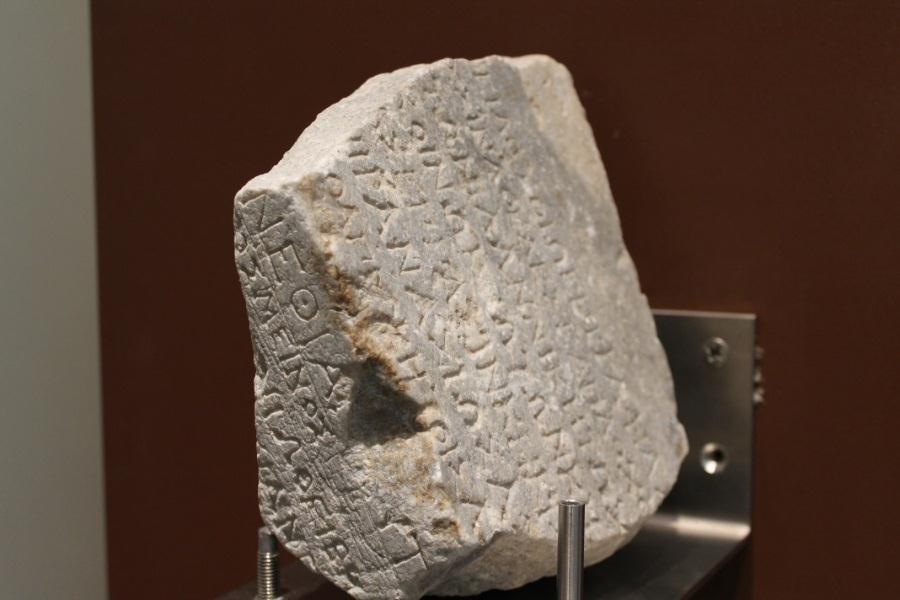 Θραύσμα από κυβόλιθο με επιγραφή στην πάνω επιφάνεια, όπου αναγράφονται αφιερώματα των Βοιωτών στο ιερό της Ιτωνίας