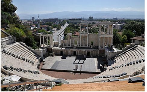 Όμως στοιχεία όπως η κιονοστοιχία του προσκηνίου και τα θυρώματα της σκηνής, που στην ελληνική φιλοξενούν κινητούς πίνακες, στο ρωμαϊκό έχουν αντικατασταθεί με μονιμότερο αρχιτεκτονικό και γλυπτικό