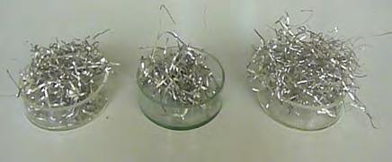 a b Sticle metalice amorfe: a) Plăci din material amorf baza Fe obţnut prin turnare în formă de Cu, b) benzi din material amorf baza Fe obţinute prin filarea topiturii pe tambur rotitor