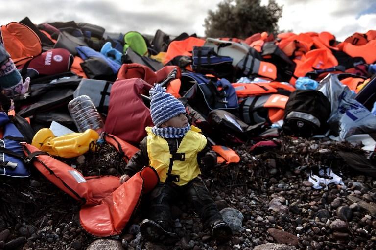 Εικόνα 23: Το μικρό προσφυγόπουλο μόλις έφτασε στη Λέσβο με τους γονείς του, οι οποίοι το έβαλαν να καθίσει μπροστά από ένα σωρό από