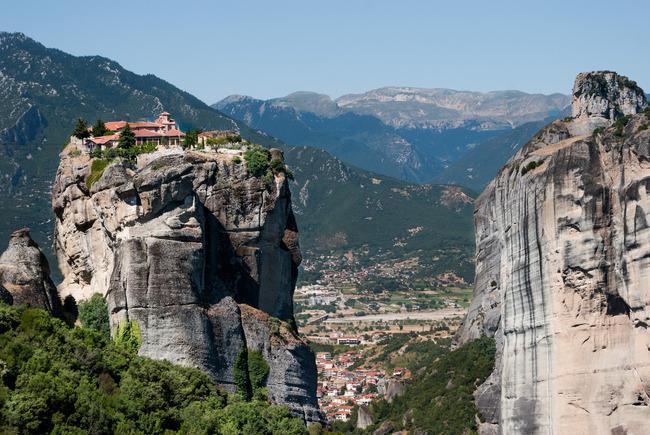 Μετέωρα Τα Μετέωρα είναι ένα σύμπλεγμα από τεράστιους σκοτεινόχρωμους βράχους από ψαμμίτη οι οποίοι υψώνονται έξω από την Καλαμπάκα, κοντά στα πρώτα υψώματα της Πίνδου και των Χασίων.