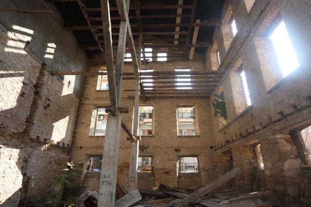 Εικ. 1: Εσωτερική άποψη του κτιρίου προς τον Νότιο τοίχο της πρόσοψης. Διακρίνονται οι οριζόντιες και κατακόρυφες αύλακες στις λιθοδομές.