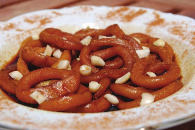 Τερτσελούθκια με χαρουπόμελο Pastry rings with carob syrup Κουλουράκια βρασμένα και βουτηγμένα σε χαρουπόμελο, σε σχήμα μικρών κρίκων.
