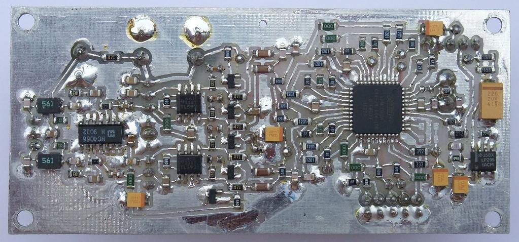 Na gornji strani tiskanine so nameščeni le redki gradniki: trije aluminijevi elektrolitski kondenzatorji, kristal za 14.