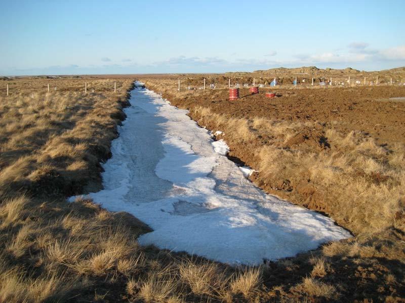 2008 kl. 8.44). Mynd 4. Frárennslisskurðurinn í Fíflholtum að morgni 4. apríl 2008. Snjóa hafði leyst af sléttlendi, en skurðurinn enn fullur.