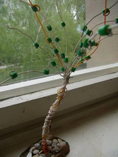Potom na drôtené konáriky navliekame zelené korálky. Aby drôtený strom stál, môžeme ho zapichnúť do plastelíny.