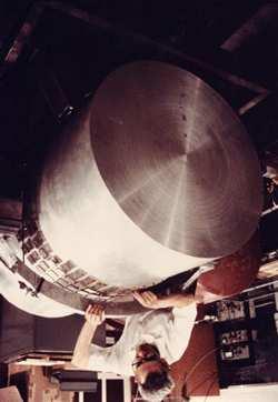 Slika 9: Joseph Weber pregleduje eno od svojih gravitacijskih anten. Sunek gravitacijskih valov naj bi povzročil nihanje delov valja.