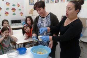 πραγματοποιείται μια Μαμάδες των μαθητών του 25ου δημοτικού σχολείου Χαλκίδας ετοιμάζουν κουλουράκια για να τα προσφέρουν τα παιδιά τους στους ηλικιωμένους, κατά την