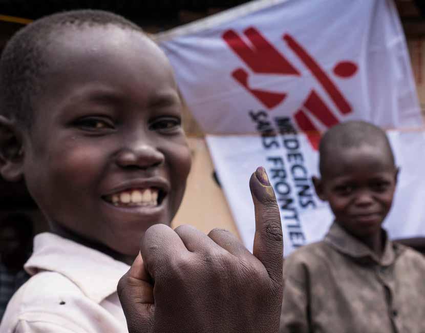 Stitching Pictures / MSF Ουγκάντα, Μάιος 2018 Σε ένα από τα κέντρα εμβολιασμού των Γιατρών Χωρίς Σύνορα, ένα νεαρό αγόρι δείχνει περήφανα το χρωματισμένο με μελάνι δάχτυλό του, απόδειξη ότι